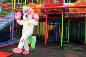 A playful unicorn mascot in a colorful play area, bringing joy and imagination to children's playtime.