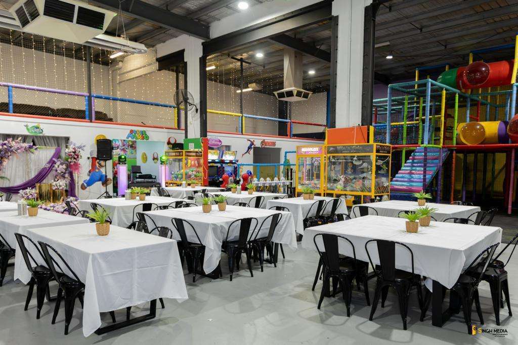 A spacious indoor play area with ample seating arrangements including tables and chairs.